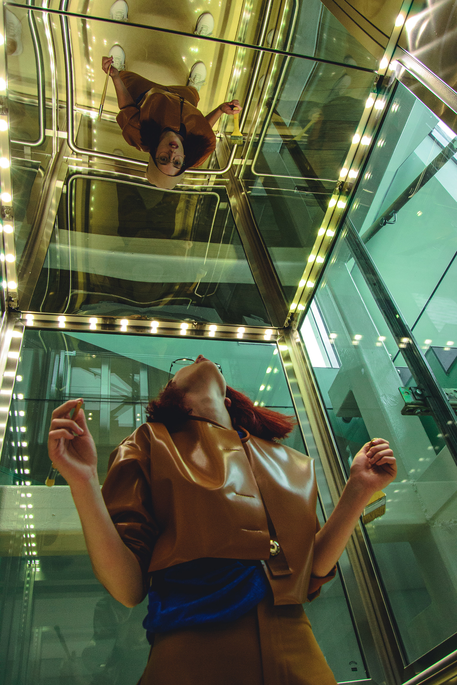 Woman looking up into a mirror in a lift